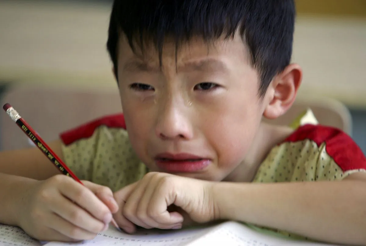 A boy cries during class at the West Point Training Center in Zhejiang on Aug. 2, 2006. A "tiger mom" in China makes her son study 16 hours everyday. (Cancan Chu/Getty Images)