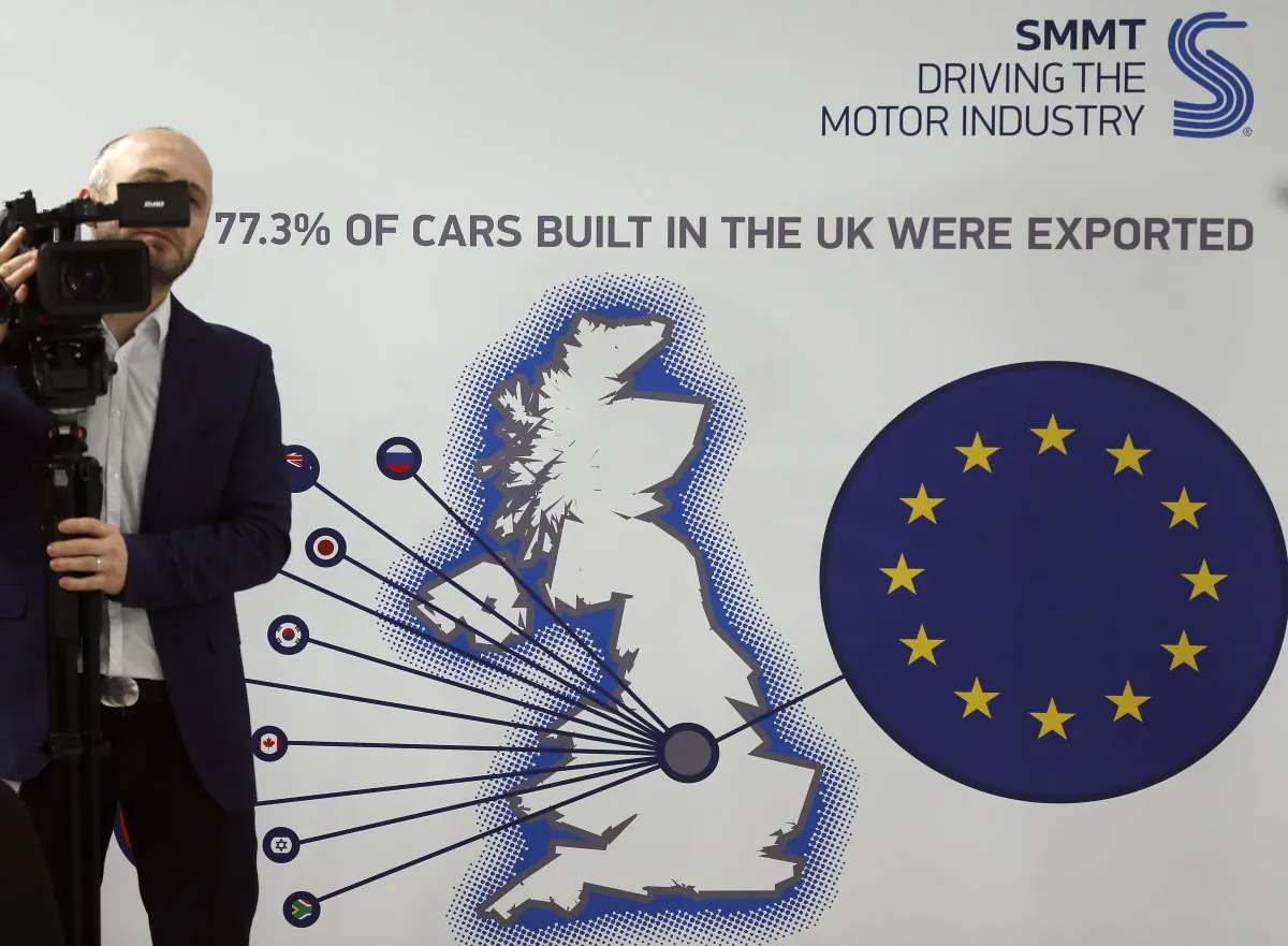 A cameraman films during a press conference of the Society of Motor Manufacturers and Traders Limited (SMMT) U.K. automotive, focusing on Europe in London, on March 3, 2016. Britain's Society of Motor Manufacturers and Traders said Thursday that 77 percent of its members backed remaining in the 28-nation bloc. Britain will hold a referendum on EU membership June 23. (AP Photo/Frank Augstein)