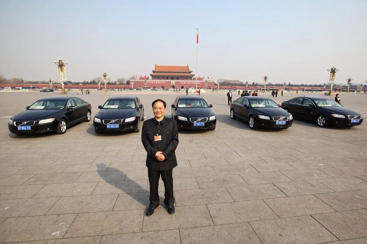 The delegate Li Shufu, chairman of China's Geely Holding Group in front of Volvo cars on the Tiananmen Square, China on March 5, 2011. (Feng Li/Getty Images)