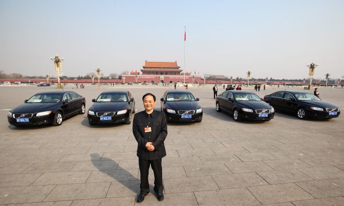 The delegate Li Shufu, chairman of China's Geely Holding Group, in front of Volvo cars on Tiananmen Square, China, on March 5, 2011. (Feng Li/Getty Images)