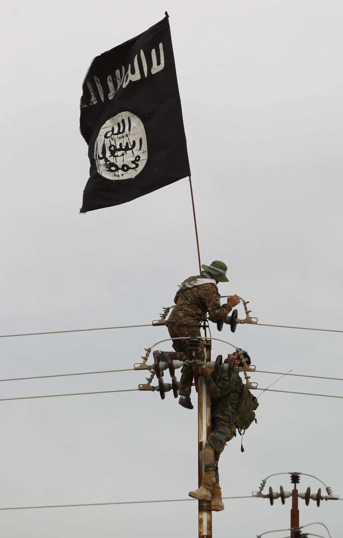 Iraqi Shiite fighters from the Popular Mobilization units take off an Islamic State flag from an electricity pole on March 3, 2016. (Ahmad al-Rubaye/AFP/Getty Images)