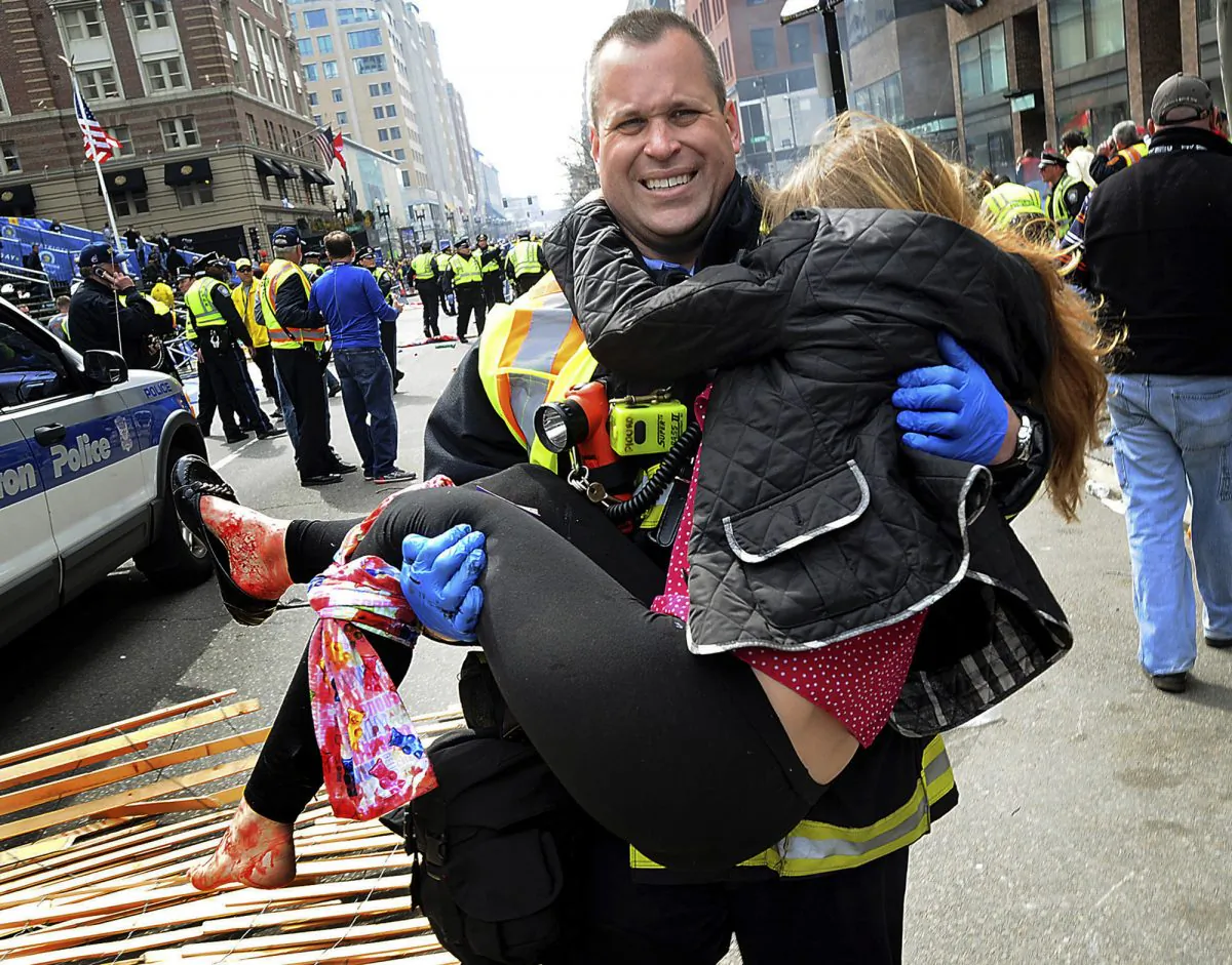 In this April 15, 2013 file photo, Boston Firefighter James Plourde carries Victoria McGrath from the scene after a bombing near the Boston Marathon finish line. A Northeastern University spokesman said Monday, March 7, 2016, that McGrath, originally from Westport, Conn., and another student were killed in a car accident in Dubai over the weekend while on a personal trip. (AP Photo/MetroWest Daily News, Ken McGagh, File) MANDATORY CREDIT: METROWEST DAILY NEWS, KEN MCGAGH
