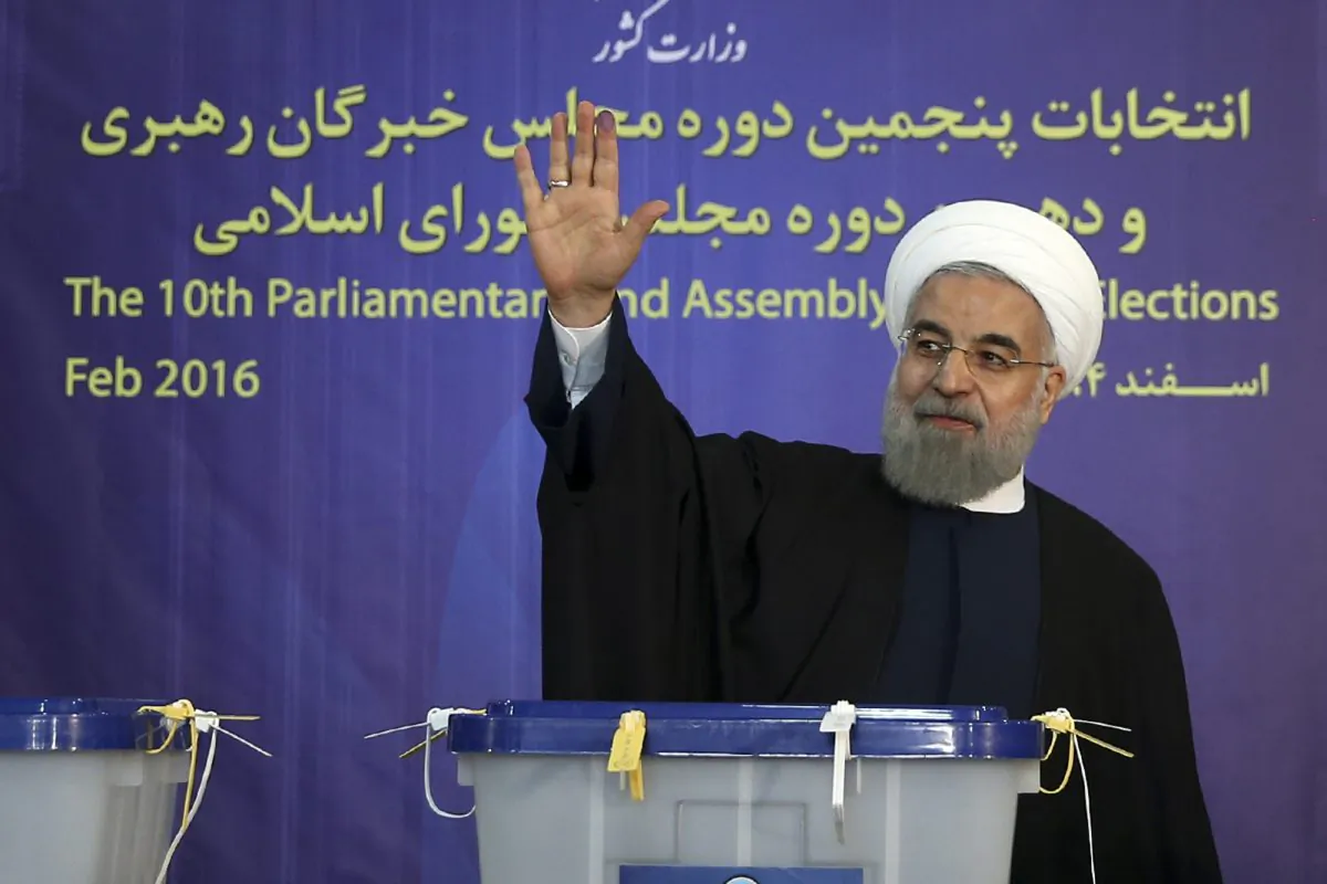 Iranian President Hassan Rouhani waves to media after casting his vote for parliamentary and Experts Assembly elections in Tehran, Iran, on Feb. 26, 2016. (Iranian Presidency Office via AP)
