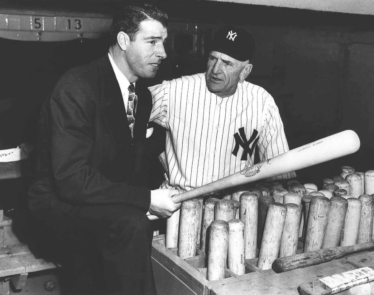 New York Yankees center fielder Joe DiMaggio speaks with manager Casey Stengel in the dugout in this undated photo. (AP Photo)