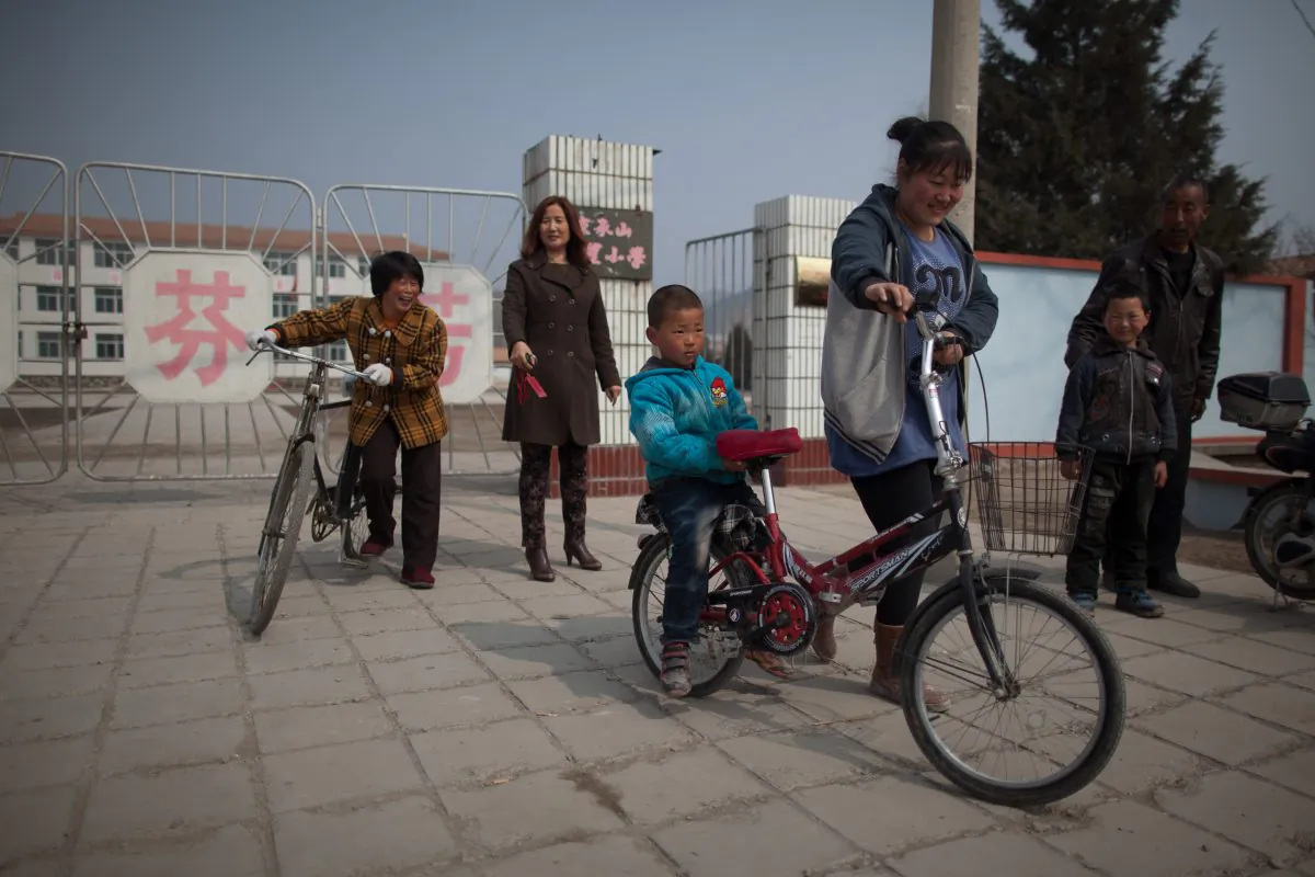 Parents and children leave a school in Chengde, Hebei Province on March 21, 2013. Middle-aged women are getting pregnant again after China loosened its one-child policy. (Ed Jones/AFP/Getty Images)