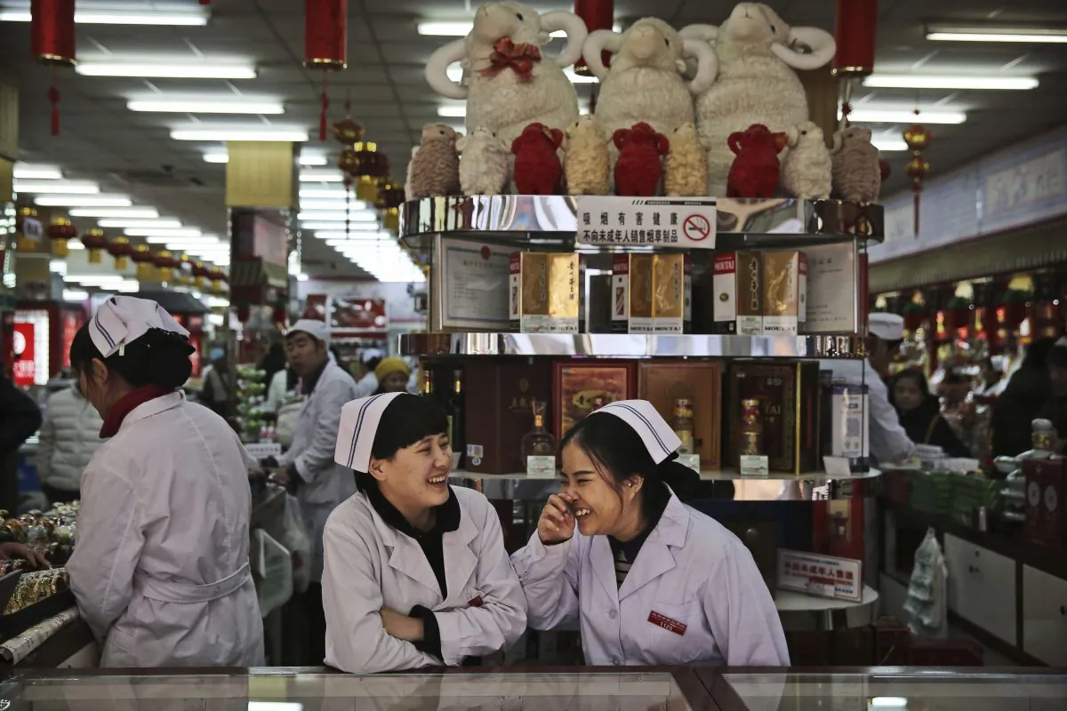 Chinese clerks chat as they wait for customers at a market in Beijing on Jan. 19, 2016.  (Kevin Frayer/Getty Images)