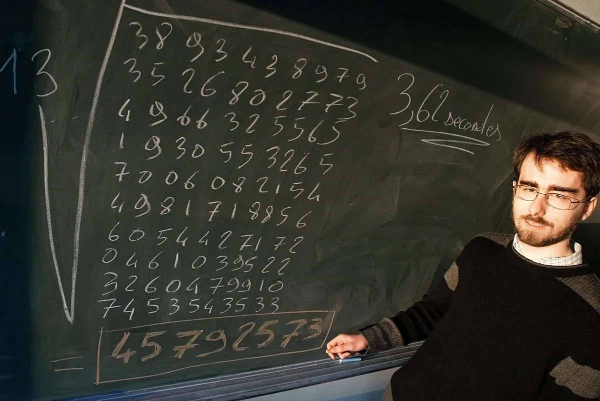 Alexis Lemaire, 24, posing in front of a blackboard in Reims, France, 20 December 2004 after he set a new world record as he became the first person to figure out the 13th root of a 200-digit number by mental arithmetic alone. (FRANCOIS NASCIMBENI/AFP/Getty Images)