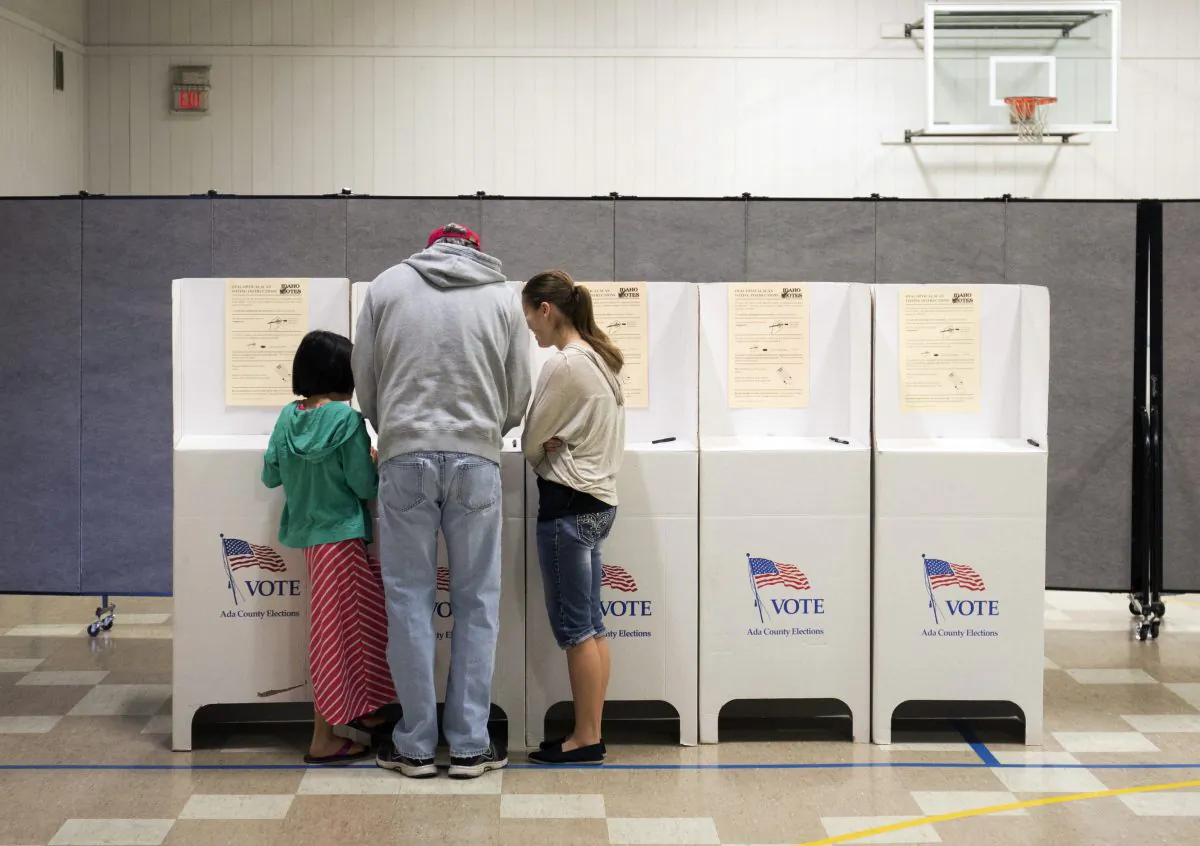 Troy Drake votes with two of his children during the primary election at Boise Bible College in Garden City, Idaho, on March 8, 2016.  (Otto Kitsinger/AP)