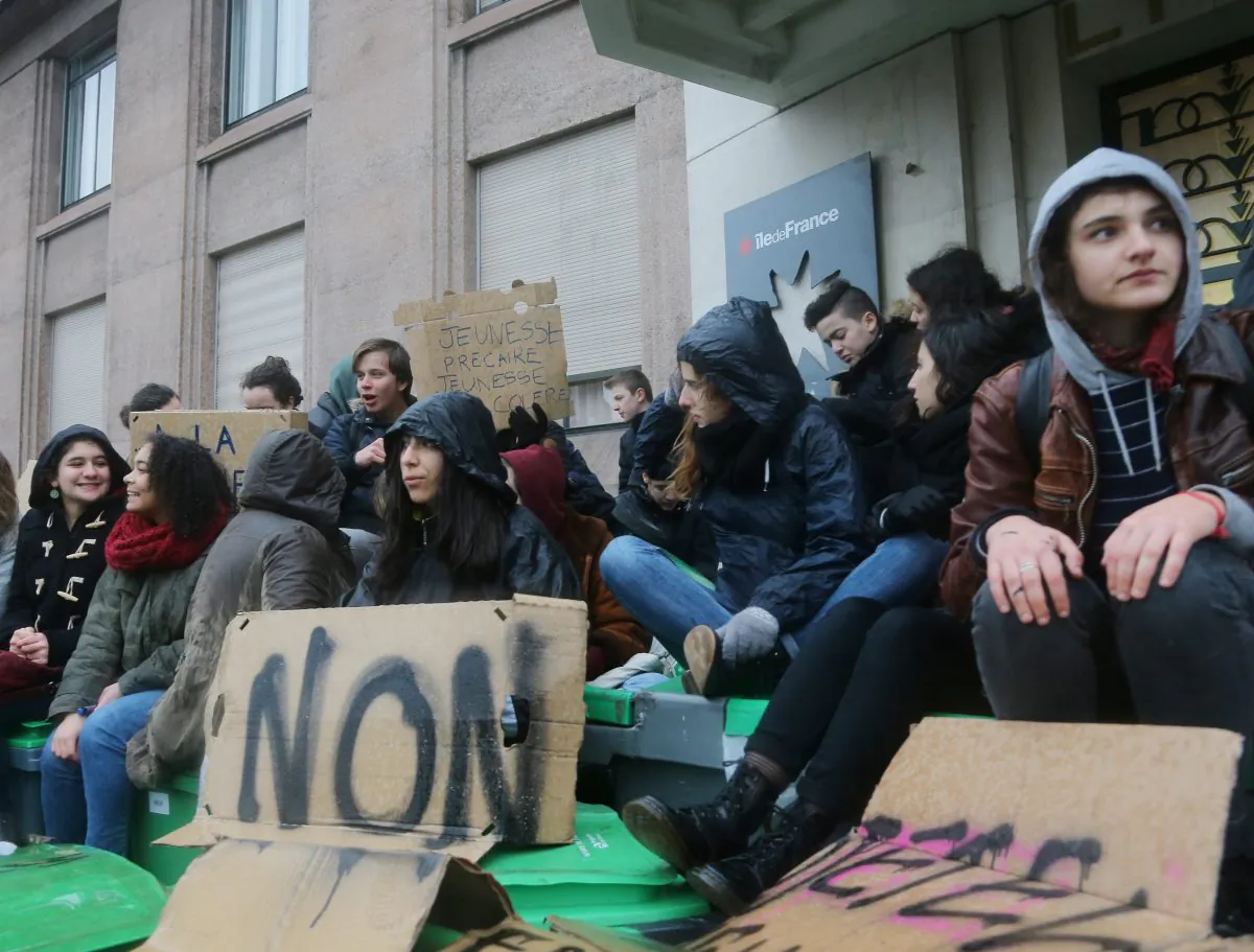 Students sit outside their high school in Paris, Wednesday , March 9, 2016. France's transport unions and youth organizations hold strikes, amid anger over proposed labor law changes that take aim at the 35-hour workweek and make layoffs easier. (AP Photo/Jacques Brinon)