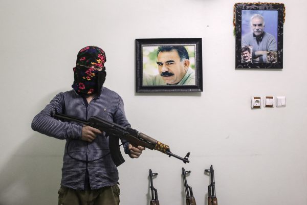 A member of a armed group Patriotic Revolutionary Youth Movement (YDG-H), a youth division of the Kurdistan Workers' Party (PKK), with his AK-47 next to pictures of the jailed Kurdish rebel leader Abdullah Ocalan in a house in southeastern Turkish city of Nusaybin, Turkey, on Feb. 25, 2016. Since mid-December, the Turkish security forces placed to several predominantly Kurdish cities in Turkey under 24-hour martial law and curfew on the premise of restoring public order. (Cagdas Erdogan/Getty Images)