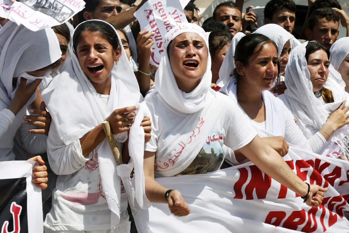 Yazidi Kurdish women chant slogans during a protest against the Islamic State group's invasion on Sinjar city one year ago, in Dohuk, northern Iraq, Monday, Aug. 3, 2015. (AP Photo/Seivan M.Salim)