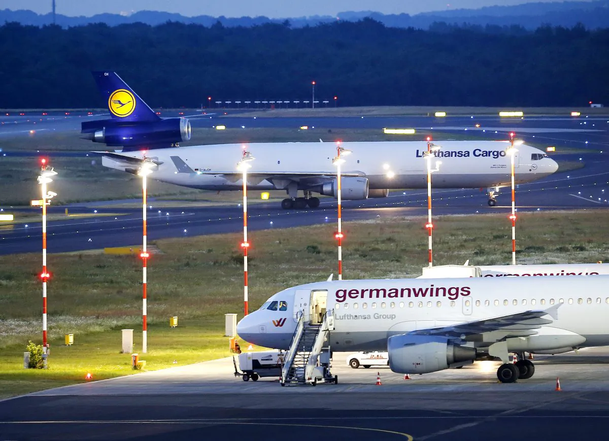 A cargo aircraft, top, with remains of several people who died in the Germanwings plane crash in France lands at the airport in Dusseldorf, Germany, Tuesday, June 9, 2015. 150 people died in the plane crash on March 24. (AP Photo/Michael Probst)