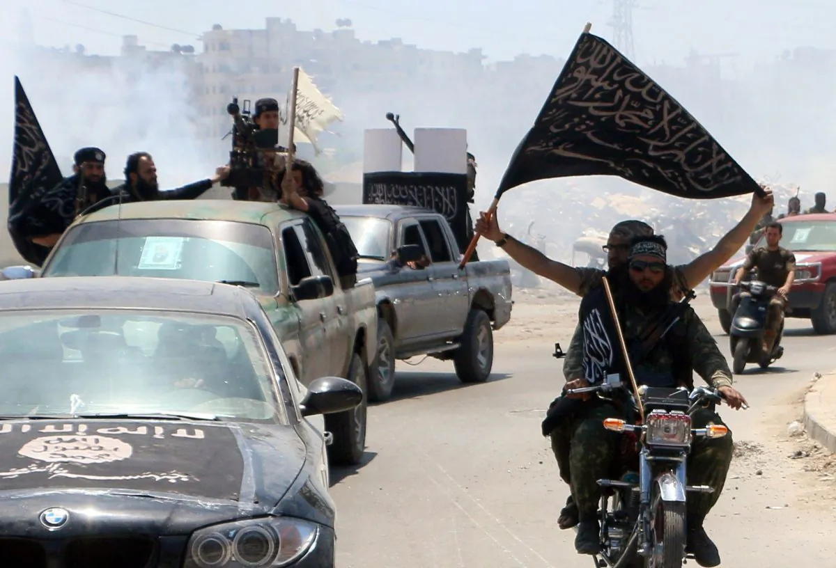 Fighters from Al-Qaida's Syrian affiliate Al-Nusra Front drive in the northern Syrian city of Aleppo flying Islamist flags as they head to a frontline, on May 26, 2015. (Fadi al-Halabi/AFP/Getty Images)