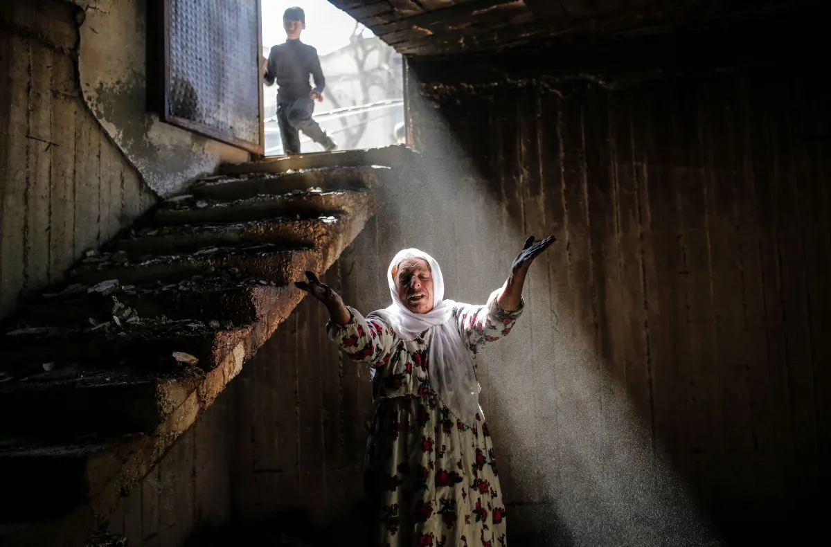 A woman reacts while walking among the ruins of damaged buildings following heavy fighting between government troops and Kurdish fighters on March 2, 2016, in the southeastern Turkey Kurdish town of Cizre, near the border with Syria and Iraq. (Yasin Akgul/AFP/Getty Images)