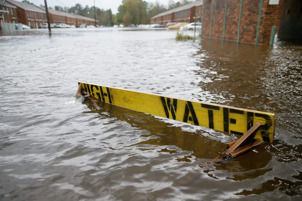 Flood waters partially submerge a "HIGH WATER" sign on Rufus Bankston Road west of Hammond, La., on March 11, 2016. (David Grunfeld/NOLA.com The Times-Picayune via AP)