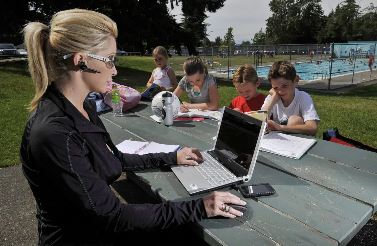 Melanie Berezan does some work on her laptop while her children (from left) Catalina, Tia, Josh and Connor do their homework prior to swimming lessons in Surrey, BC, June 14, 2010. Berezan often takes her laptop and gadgets with her to work while at her kids' activities in an effort to balance the demands of work and parenting. THE CANADIAN PRESS/Richard Lam