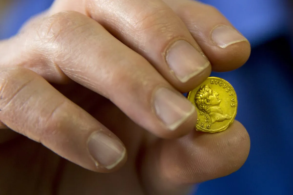 Israeli Antiquities Authority official Donald T. Ariel holds a rare, nearly 2,000-year-old gold coin, at the Antiquities Authority office inside the Israel Museum in Jerusalem, Monday, March 14, 2016. (AP Photo/Ariel Schalit)