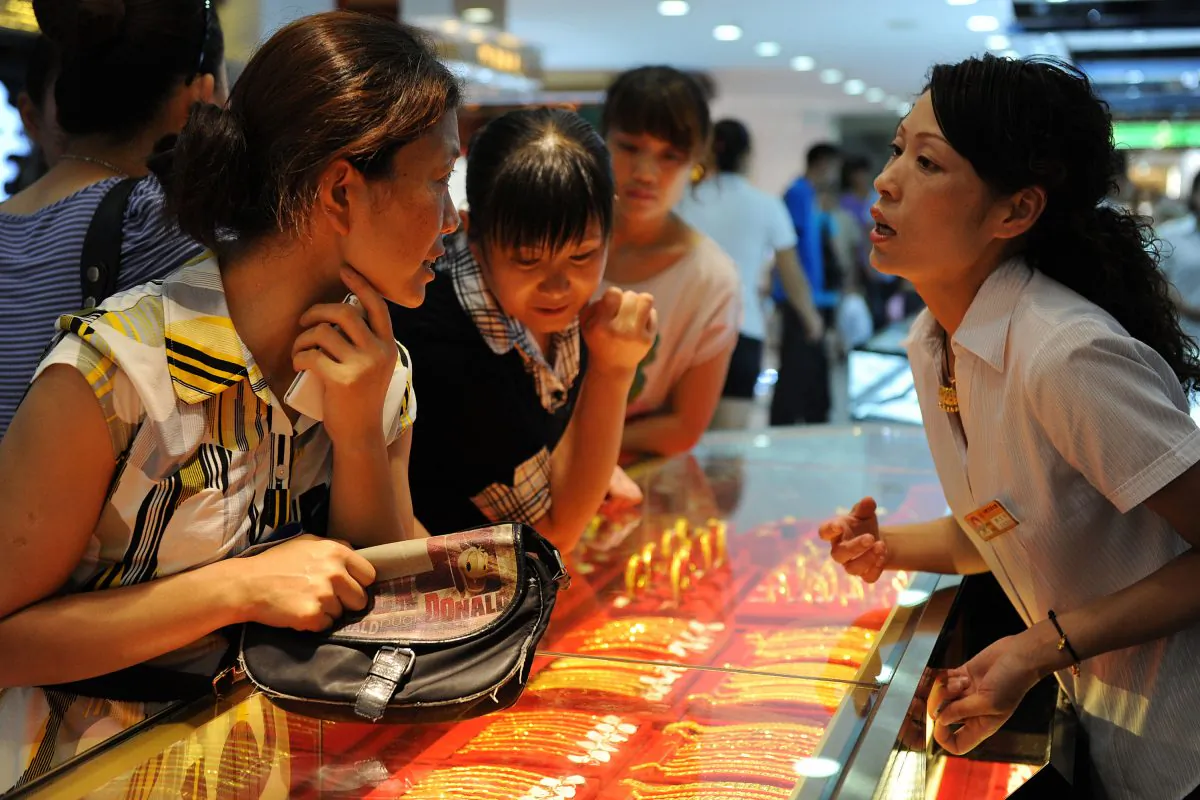 Customers look at gold jewellery on display at a shop in Hefei, east China's Anhui province on August 23, 2010. (STR/AFP/Getty Images)
