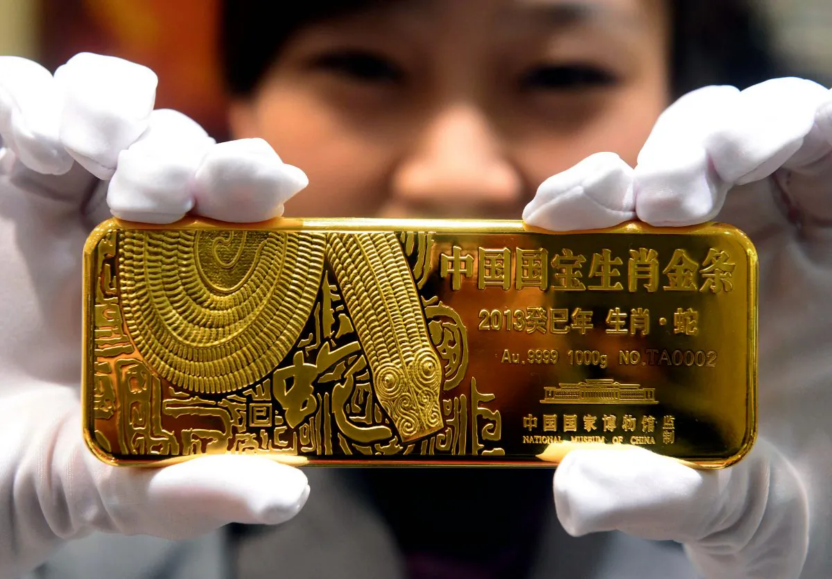 A woman holds a gold bar to mark the year of the snake in Beijing in 2012.  (STR/AFP/Getty Images)