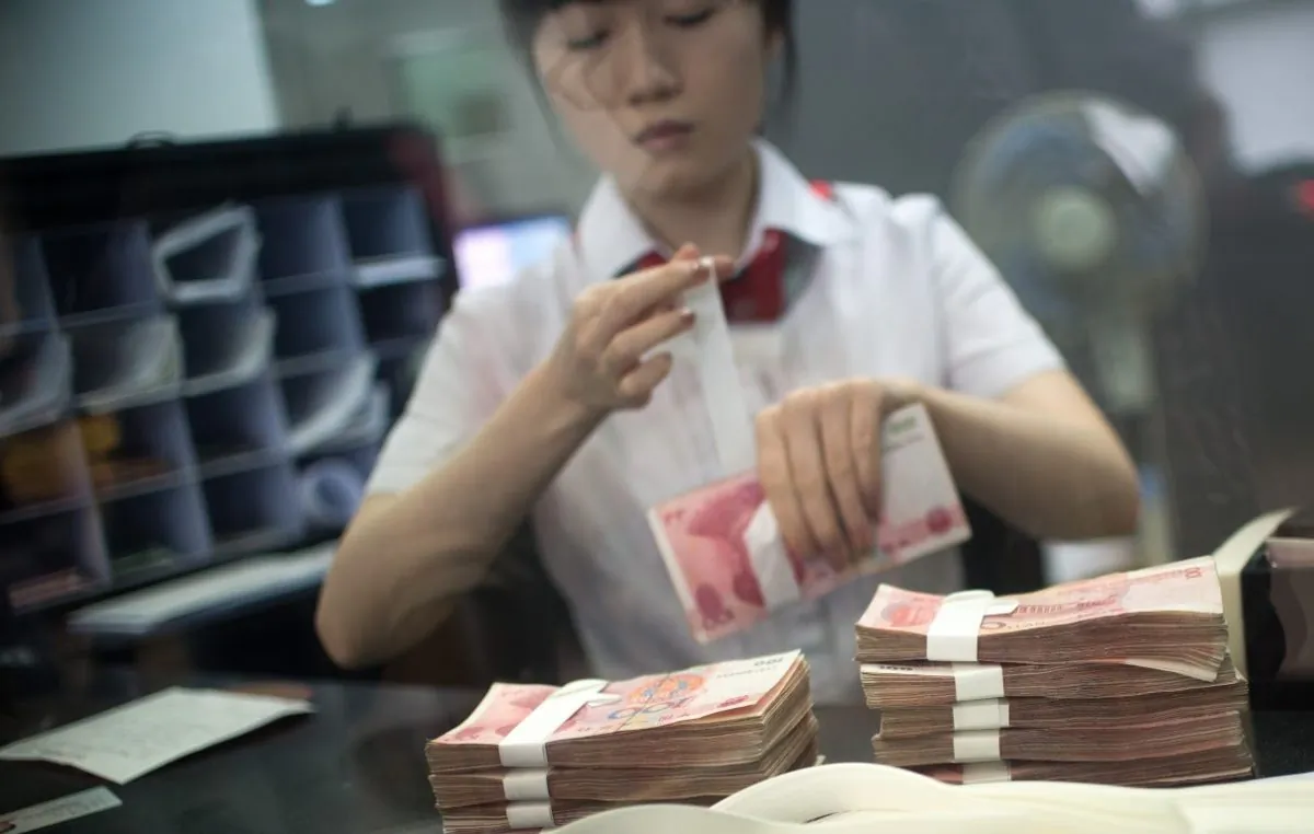 A worker of an Industrial and Commercial Bank of China Ltd (ICBC) branch counts money as she serves a customer on September 24, 2014. (JOHANNES EISELE/AFP/Getty Images)