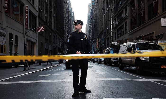 A police offficer stand at the scene of a midtown shooting that left one dead with two others wounded in New York City on Nov. 9, 2015. (Spencer Platt/Getty Images)