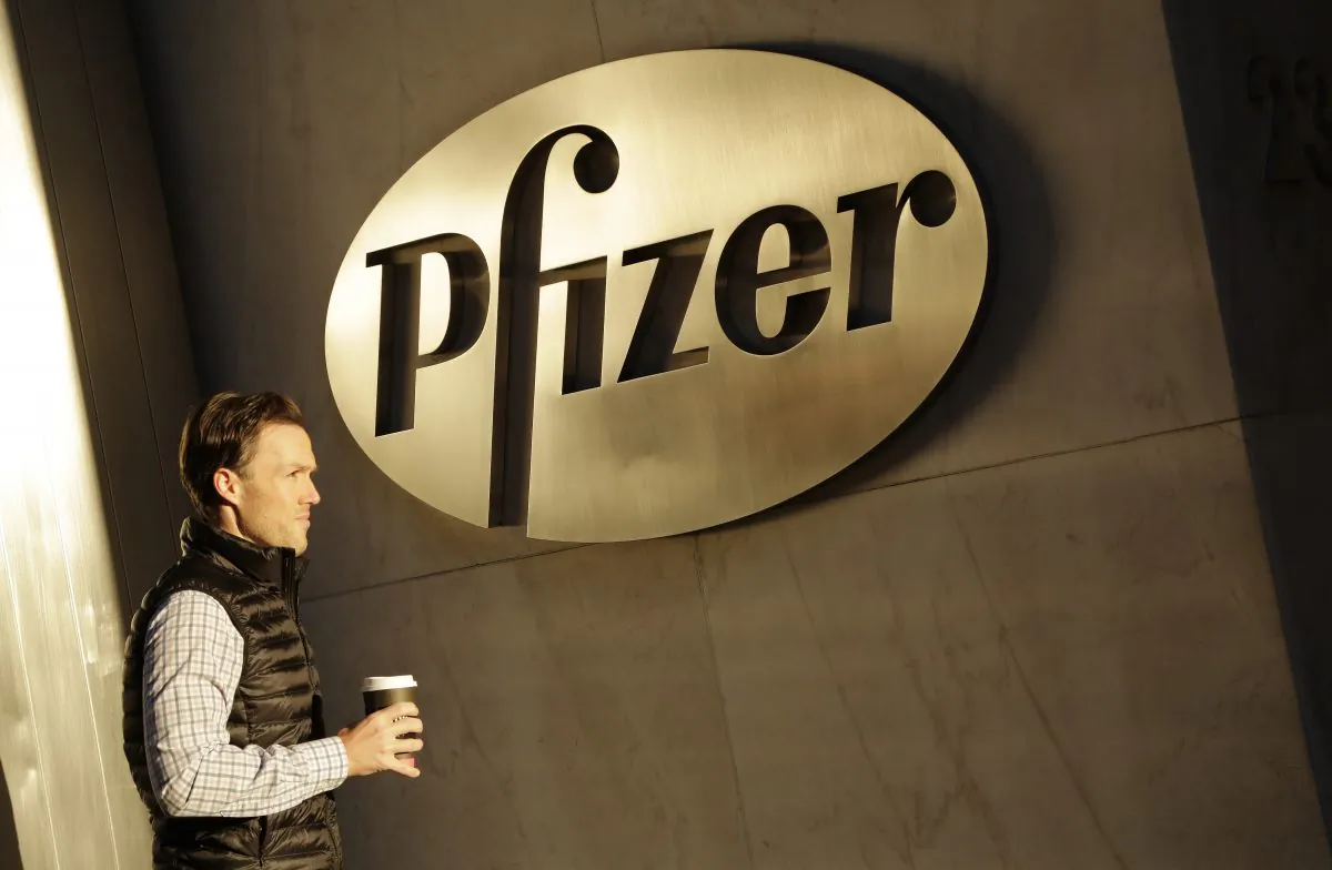 FILE - In this Monday, Nov. 23, 2015, file photo, a man enters Pfizer's world headquarters, in New York. U.S. Republican presidential candidate Donald Trump is railing about what’s wrong in corporate America as he woos voters fed up with the status quo. He is blasting drugmaker Pfizer’s tax-saving plan to move its headquarters overseas, refusing to eat Oreo cookies made in Mexico and vowing to get Apple to make iPhones in the U.S. His tirades about unfair competition, tax evasion and lost jobs trumpet a familiar tune, but going further than many others running for president have dared. (AP Photo/Mark Lennihan, File)