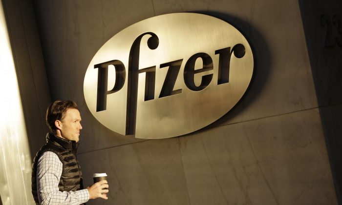 FILE - In this Monday, Nov. 23, 2015, file photo, a man enters Pfizer's world headquarters, in New York. U.S. Republican presidential candidate Donald Trump is railing about what’s wrong in corporate America as he woos voters fed up with the status quo. He is blasting drugmaker Pfizer’s tax-saving plan to move its headquarters overseas, refusing to eat Oreo cookies made in Mexico and vowing to get Apple to make iPhones in the U.S. His tirades about unfair competition, tax evasion and lost jobs trumpet a familiar tune, but going further than many others running for president have dared. (AP Photo/Mark Lennihan, File)