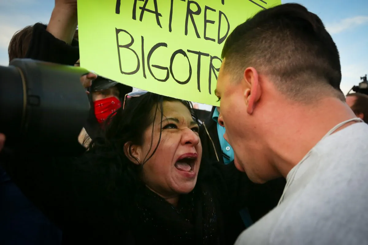 A protester confronts a supporter of Republican presidential candidate Donald Trump in downtown Salt Lake City as Donald Trump gave his first campaign speech in Utah on Friday, Mar. 18, 2016. (Benjamin Zack/Standard-Examiner via AP)
