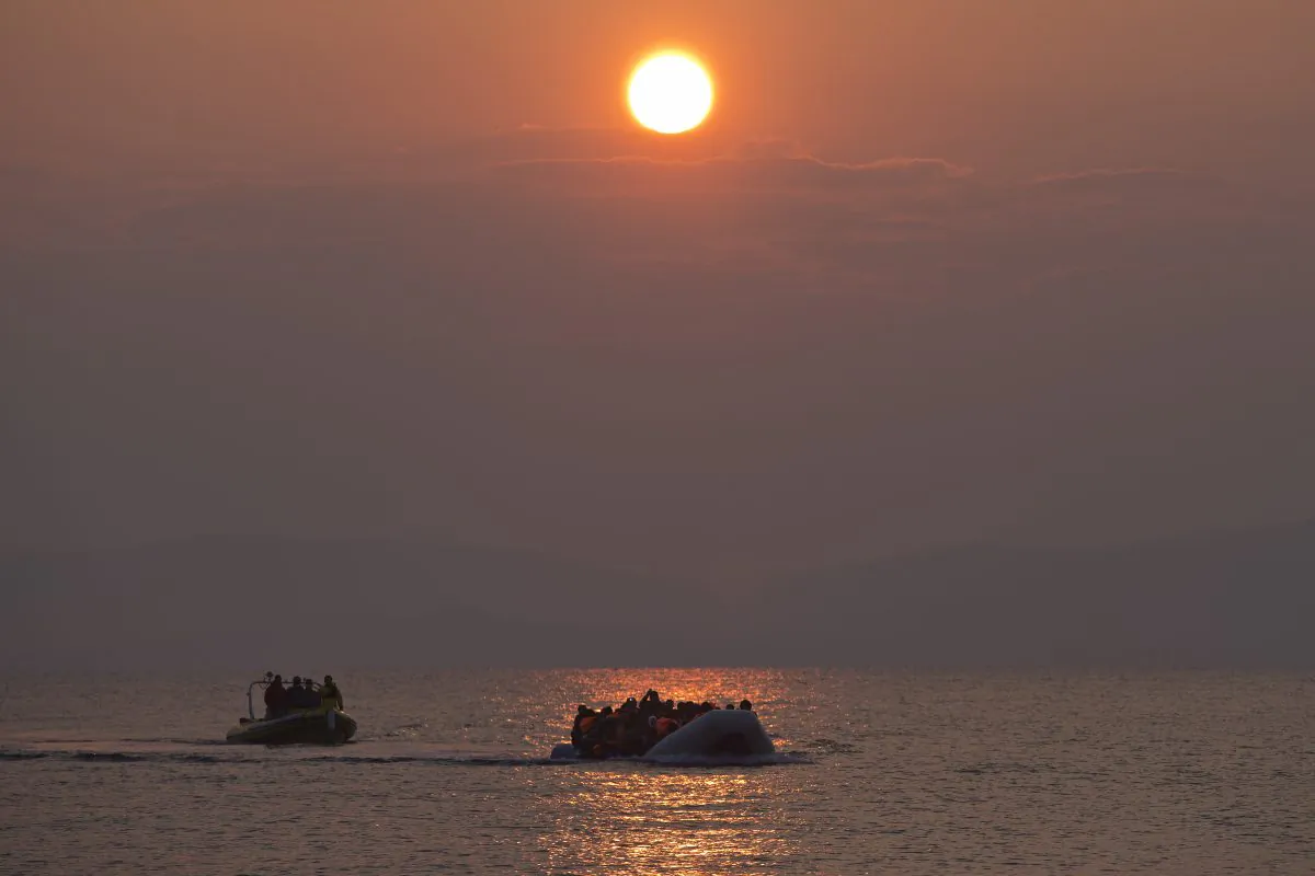 The sun rises as migrants and refugees on a dingy arrive at the shore of the northeastern Greek island of Lesbos, after crossing the Aegean sea from Turkey on March 20, 2016. In another incident two Syrian refugees have been found dead on a boat on the first day of the implementation of an agreement between the EU and Turkey on handling the new arrivals. (AP Photo/Petros Giannakouris)