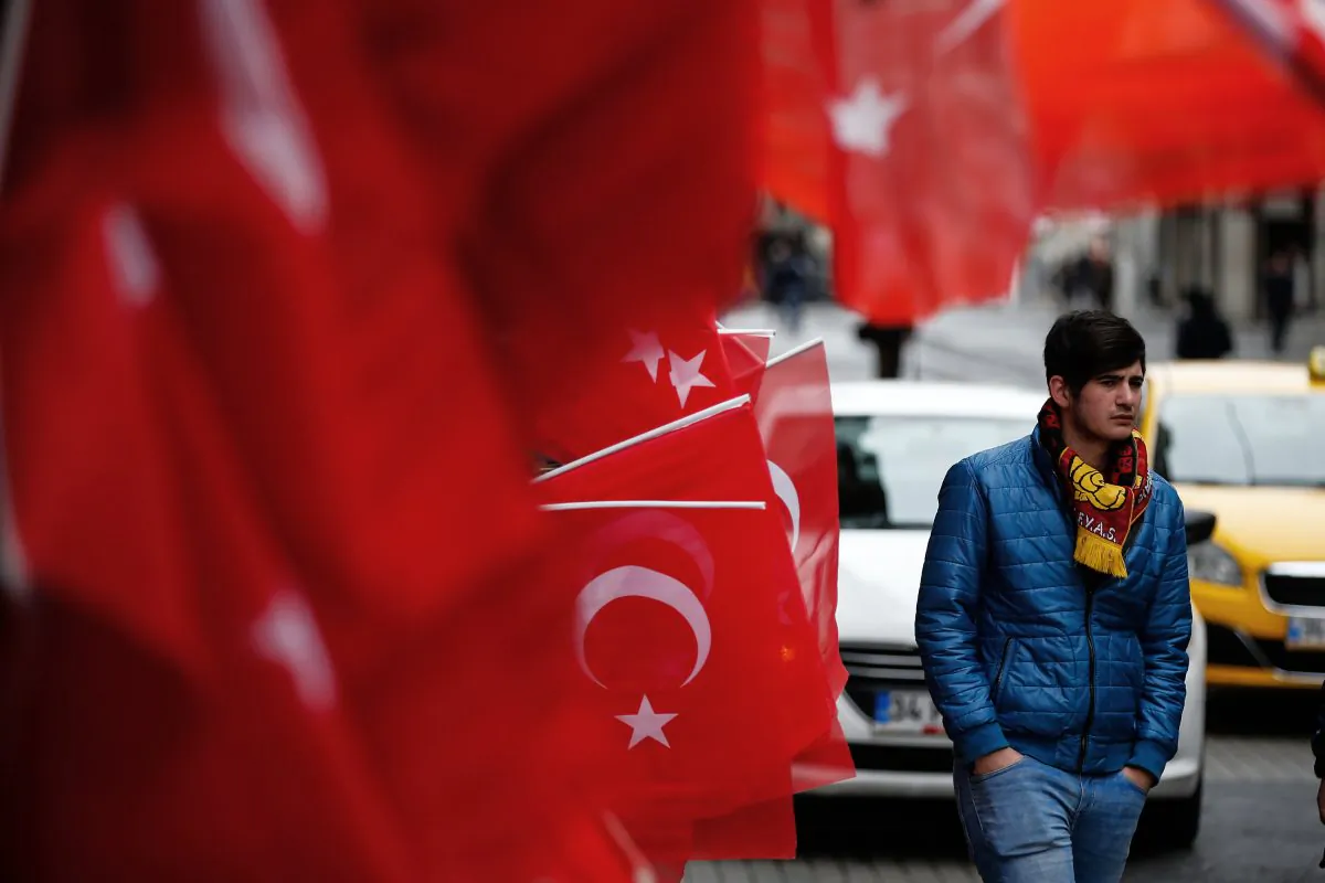 A man walks by the explosion site in Istanbul on March 20, 2016. A suicide attack on Istanbul's main pedestrian shopping street Saturday killed a number of people, including two dual nationality Israeli-Americans and one Iranian citizen, and wounded several dozen others, in the sixth suicide bombing in Turkey in the past year. The messages read: " We are here and we are not afraid." (AP Photo/Emrah Gurel)