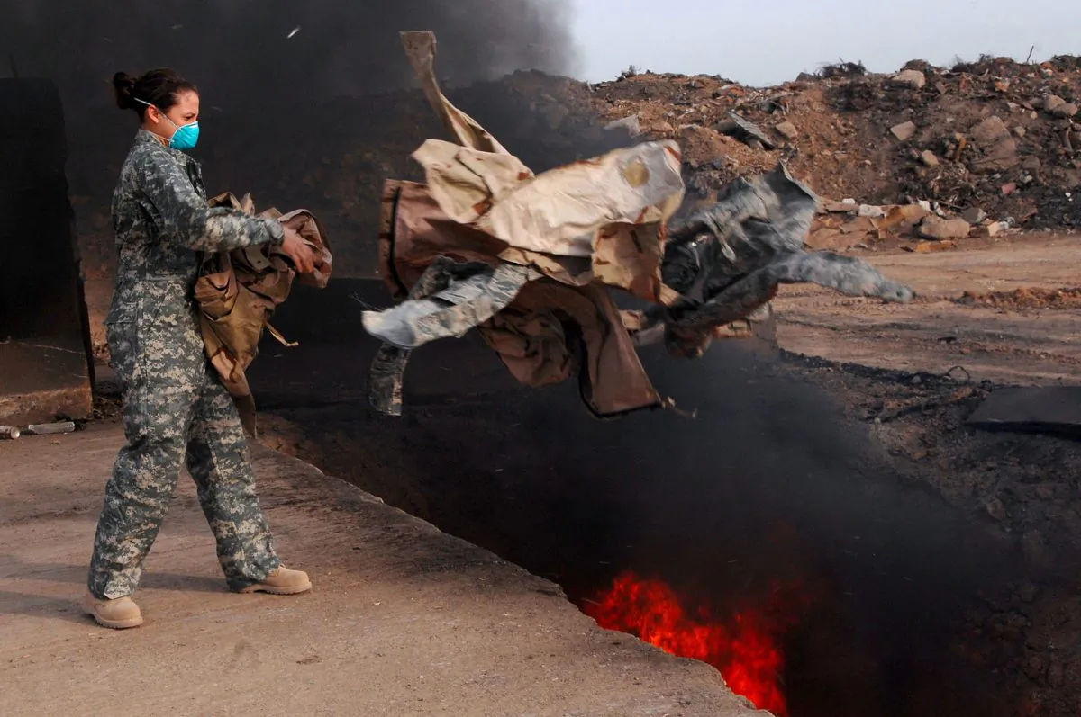 U.S. Air Force Senior Airman Frances Gavalis, 332nd Expeditionary Logistics Readiness Squadron equipment manager, tosses unserviceable uniform items into a burn pit at Balad Air Base, Iraq, on March 10, 2008. Military uniform items turned in must be burned to ensure they cannot be used by opposing forces. (U.S. Department of Defense, Public Domain)