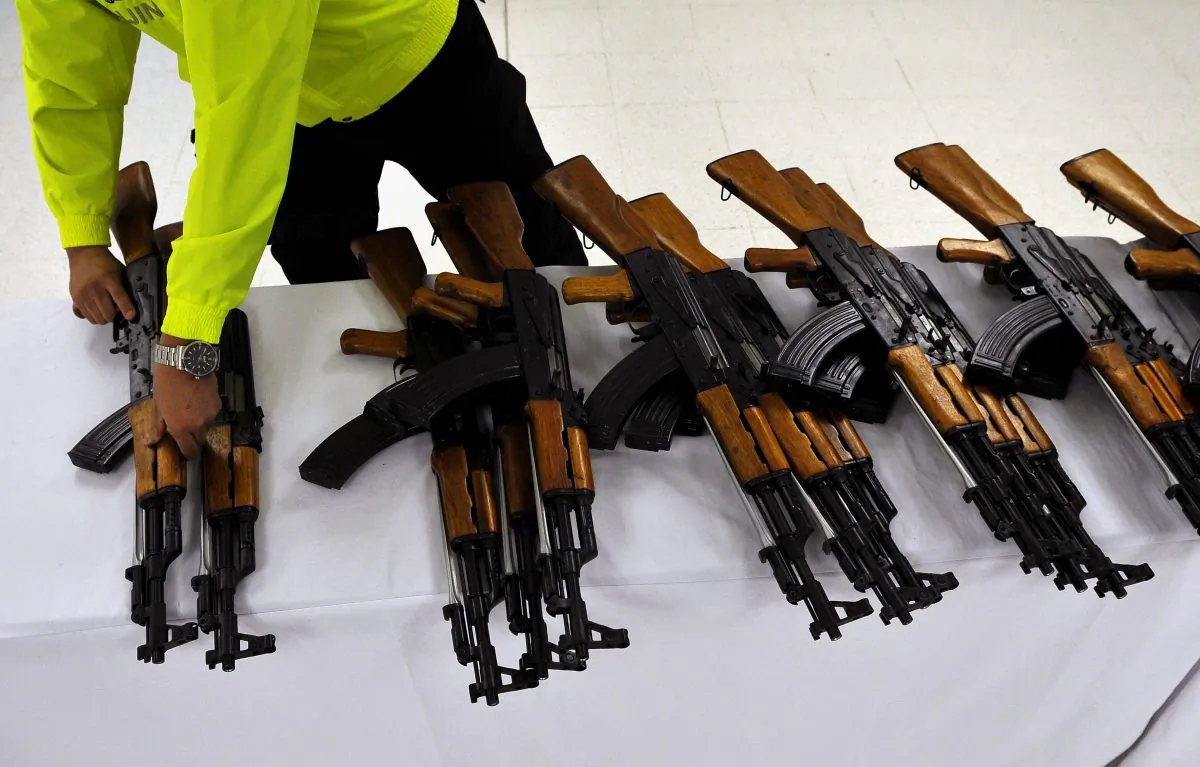 A Colombian police officer arranges rifles seized in Cali, Valle del Cauca department, Colombia on July 29, 2011. The Colombian police seized 47 Chinese-made 7.62mm Norinco assault rifles (AK-47 replicas) and 214 magazines. (Luis Robayo/AFP/Getty Images)