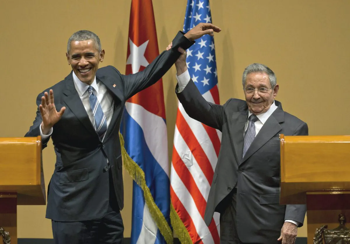 Cuban President Raul Castro, right, lifts up the arm of President Barack Obama at the conclusion of their joint news conference at the Palace of the Revolution, Monday, March 21, 2016, in Havana, Cuba. (AP Photo/Ramon Espinosa)