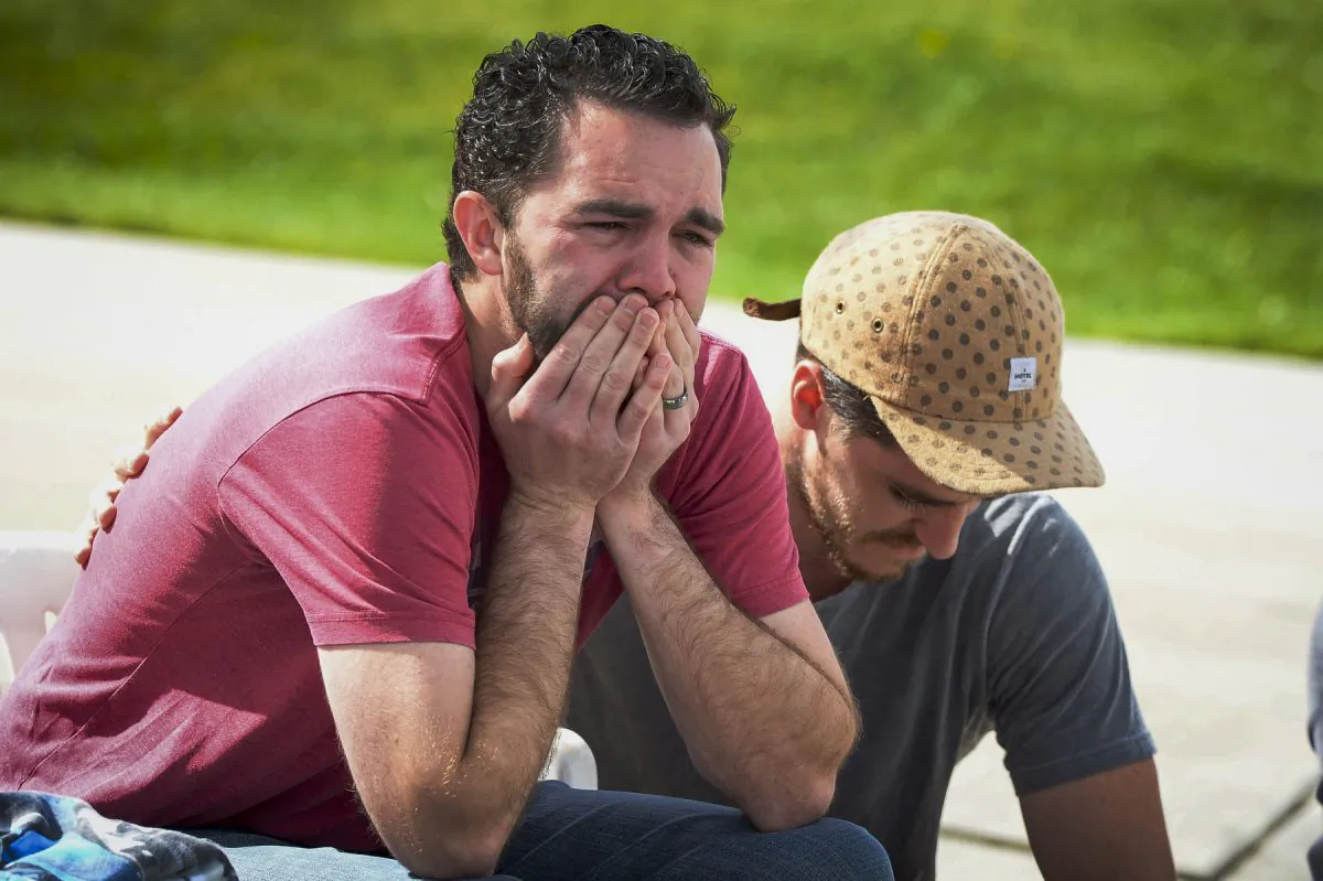 Rusty Page, foster father to Lexi, 6, is comforted by Graham Kelly after getting the news that family services will come to take Lexi away outside his home in Santa Clarita, Calif., Monday, March 21, 2016. Lexi, who spent most of her life with California foster parents, was removed from her home on Monday under a court order that concluded her native American blood requires her placement with relatives in Utah. (David Crane/Los Angeles Daily News via AP)