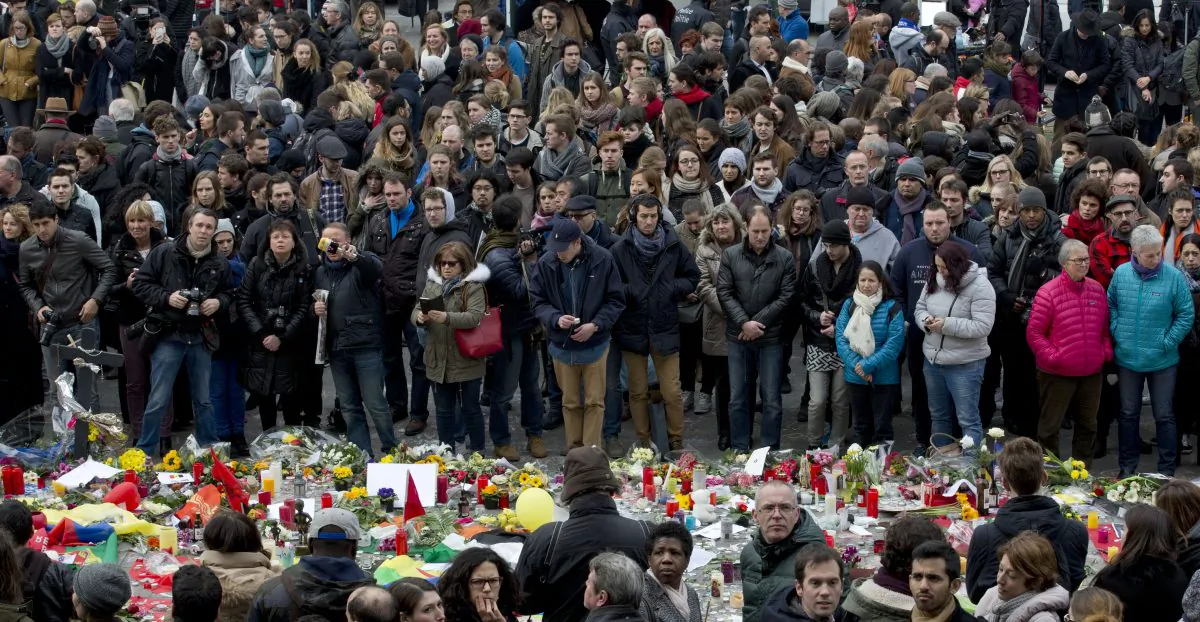 People gathered to observe a minute of silence and mourn for the victims of the bombings at the Place de la Bourse in the center of Brussels, Belgium, Thursday, March 24, 2016. (AP Photo/Peter Dejong)