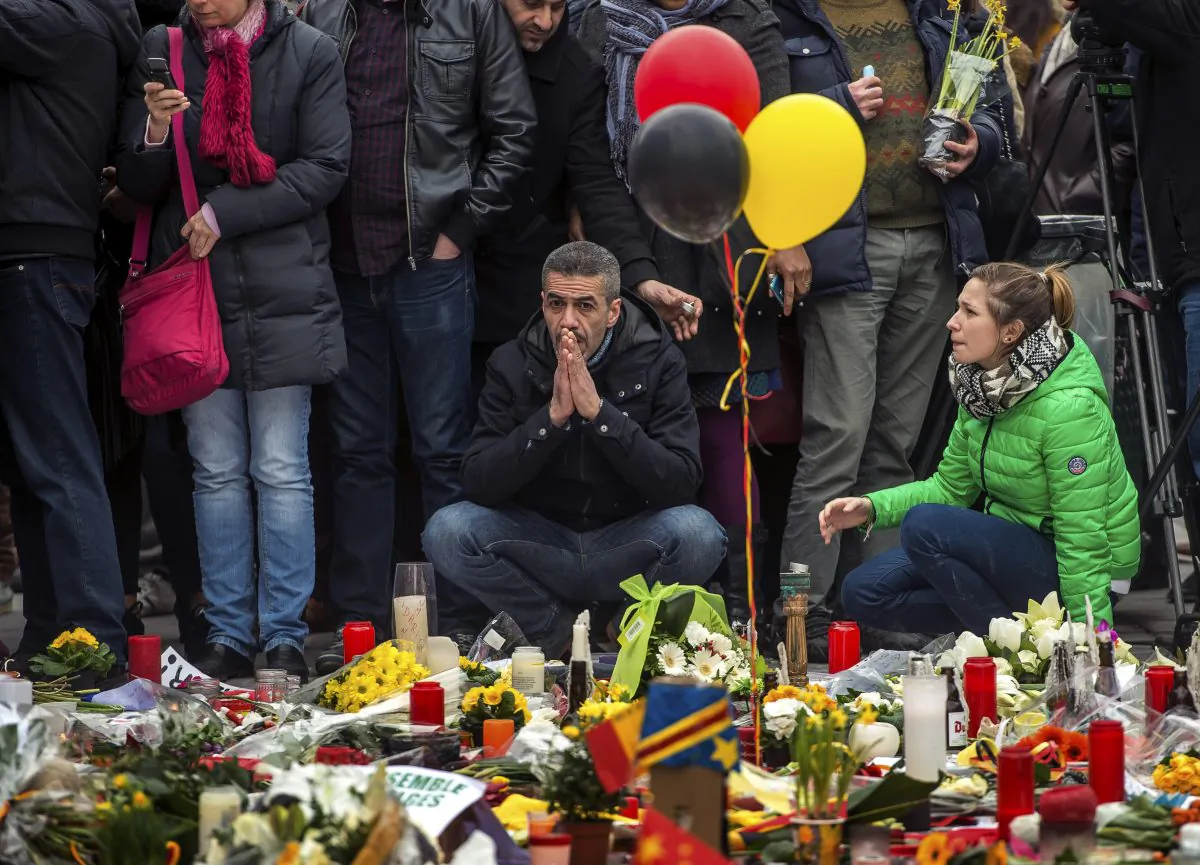 A man sits in front of a makeshift memorial to pay tribute to the victims of the Brussels attacks on the Place de la Bourse (Beursplein) in central Brussels, on March 24, 2016. (Phillipe Huguen/AFP/Getty Images)