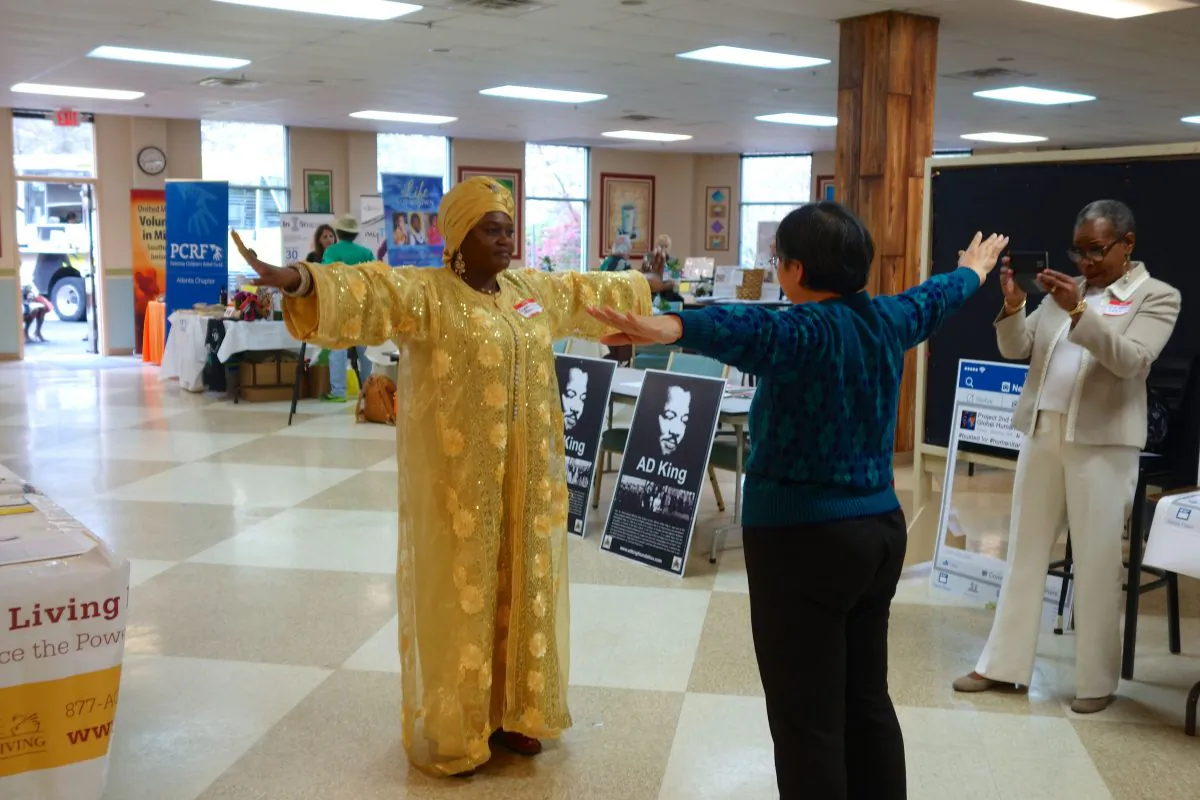 Ayi Zhou (R) teaches Falun Gong exercises during the Global Humanitarian Summit in Marietta, Ga., on March 19, 2016. (Mary Silver/Epoch Times)