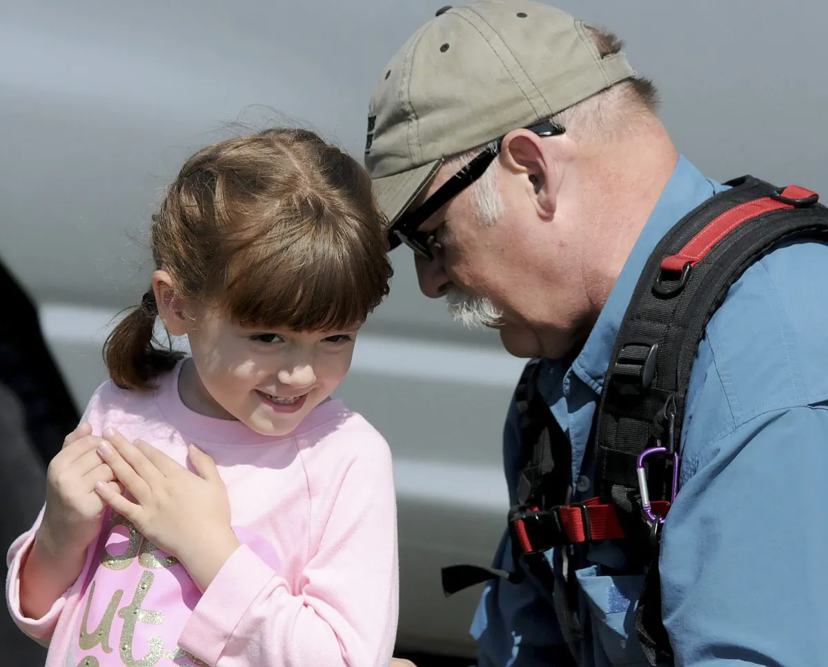 Elizabeth "Lizzy" Myers, left, being fitted for a microphone by a CBS sound man before taping a segment in Lucas, Ohio.  (Jason J. Molyet/News Journal via AP) 