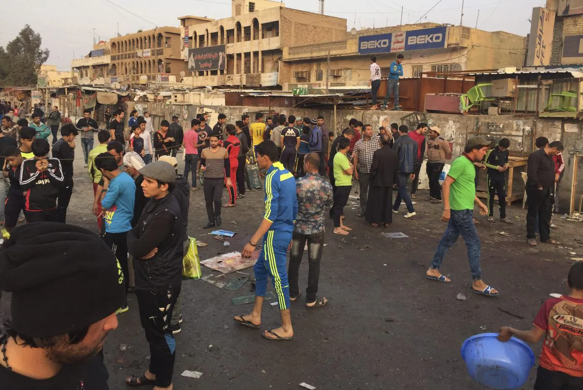 People gather at the scene of deadly bombing attacks in Sadr City, Baghdad, Iraq, Sunday, Feb. 28, 2016. Militants attacked Mredi outdoor market on Sunday in eastern Baghdad, killing at least 24 people and wounding dozens, officials said. Minutes later, a suicide bomber blew himself up amid the crowd that had gathered at the site of the first bombing, he added. (AP Photo/Ali Abdul Hassan)