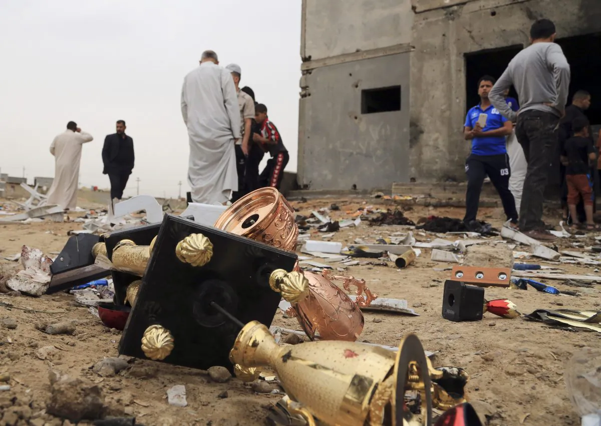 Broken Cups lie on the ground as people inspect the aftermath of a suicide bombing at a soccer field in Iskandariya, 25 miles (about 40 kilometers) south of Baghdad, Iraq, Saturday, March 26, 2016. A suicide bomber killed and wounded dozens in an attack on a crowd gathered at a soccer stadium south of Baghdad on Friday. (AP Photo/Karim Kadim)