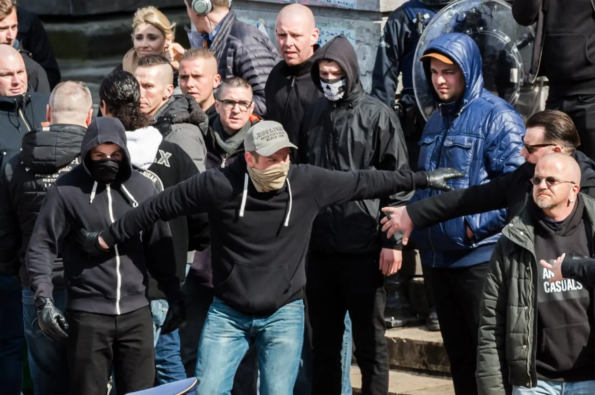 Right wing demonstrators protest at a memorial site at the Place de la Bourse in Brussels, Sunday, March 27, 2016. In a sign of the tensions in the Belgian capital and the way security services are stretched across the country, Belgium's interior minister appealed to residents not to march Sunday in Brussels in solidarity with the victims. (AP Photo/Geert Vanden Wijngaert)