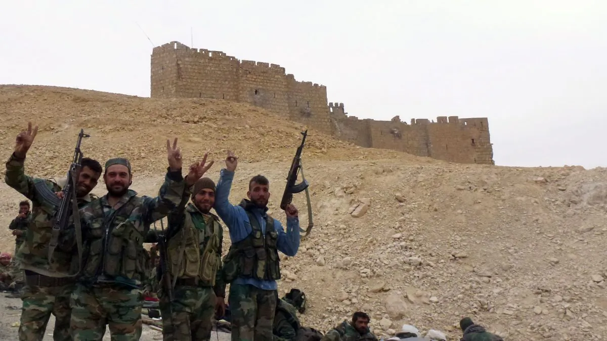Syrian pro-governement forces gesture next to the Palmyra citadel on March 26, 2016, during a military operation to retake the ancient city from the jihadist Islamic State. (Maher al-Mounes/AFP/Getty Images)
