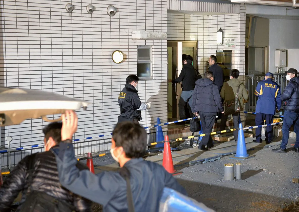 Police officers arrive for investigation of the apartment of abduction suspect Kabu Terauchi in Tokyo on Monday (Kyodo News via AP)