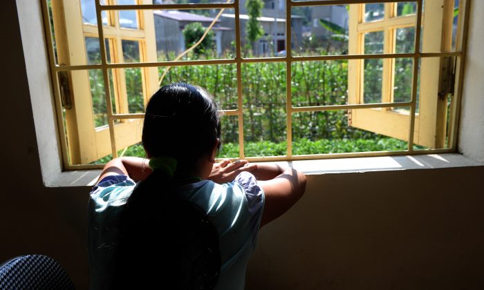 H'mong ethnic girl Kiab (a pseudonym to protect her identity) looks out a window at a center for trafficked women in the northern city of Lao Cai on May 9, 2014. When Kiab turned 16, her brother promised to take her to a party in a tourist town in northern Vietnam. Instead, he sold her to a Chinese family as a bride. (Hoang Dinh Nam/AFP/Getty Images)