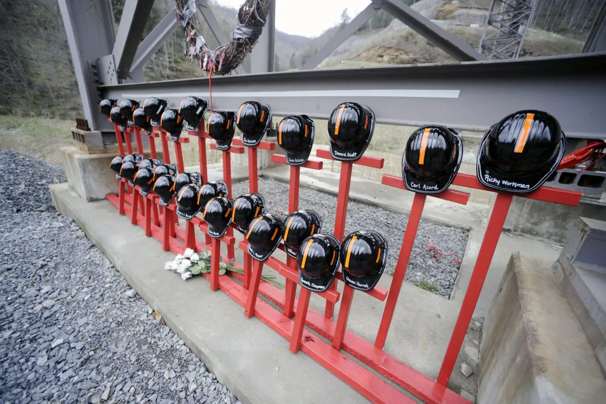 Mine helmets and painted crosses sit at the entrance to Massey Energy's Upper Big Branch coal mine Tuesday, April 5, 2011 in Montcoal, W.Va. The memorial represents the 29 coal miners who were killed in an explosion at the mine one year ago today. (AP Photo/Jeff Gentner)