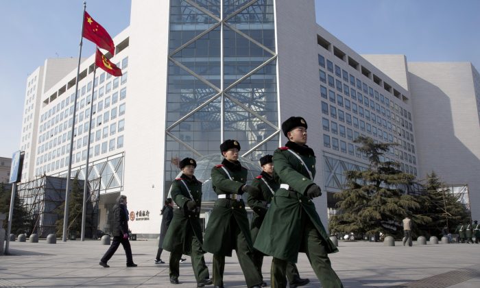 Chinese paramilitary policemen march outside the Bank of China headquarters in Beijing, China, on Feb. 25, 2016.  (AP Photo/Ng Han Guan)