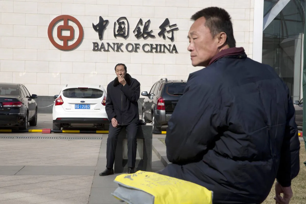 Chinese men sit outside the Bank of China headquarters in Beijing, China, on Feb. 25, 2016. (AP Photo/Ng Han Guan)