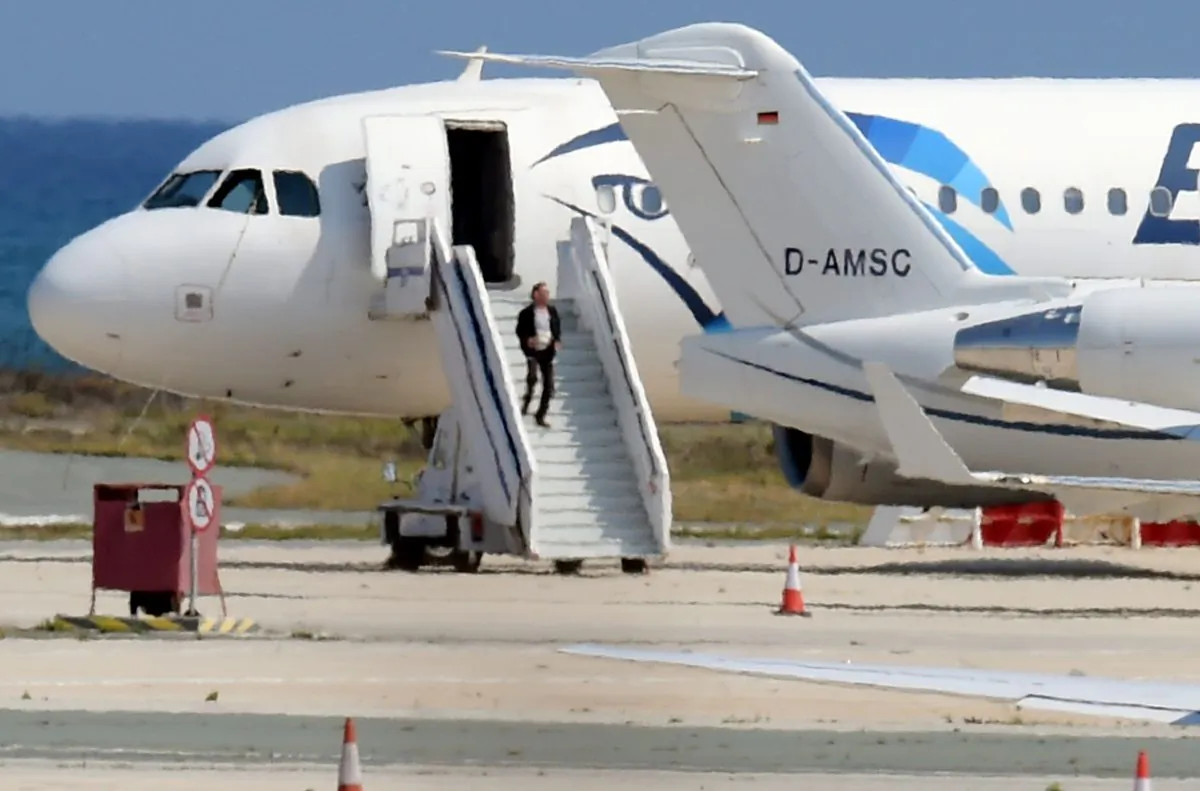 A man believed to be the hijacker of the EgyptAir Airbus A-320, which was diverted to Cyprus, leaves the plane before surrendering to security forces after a six-hour standoff on the tarmac at Larnaca airport's largely disused old terminal on March 29. 
The hijacker has been detained. (GEORGE MICHAEL/AFP/Getty Images)