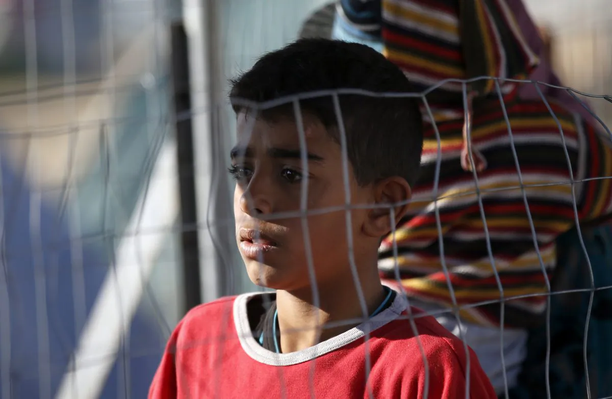 A migrant boy waits for food in the makeshift refugee camp at the northern Greek border point of Idomeni, Greece, Wednesday, March 30, 2016. Hundreds of migrants and refugees have arrived on Greek islands after days of low numbers, despite a European Union-Turkey agreement under which new arrivals will be sent back to Turkey. Figures released by the Greek government Wednesday showed 766 people reached the islands of Lesbos, Samos, Chios and Kos in the 24 hours until Wednesday morning. (AP Photo/Darko Vojinovic)
