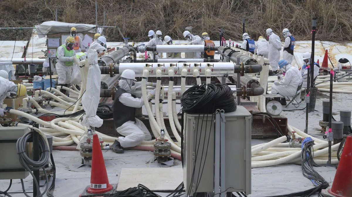 In this March 10, 2014 file photo, workers wearing protective gears install a trial model of the underground frozen wall at the Fukushima Dai-ichi nuclear power plant in Okuma, Fukushima prefecture, northeastern Japan in their attempt to stop the leakage of radioactive water that has accumulated at the crippled nuclear power plant. (AP Photo/Koji Sasahara, Pool)